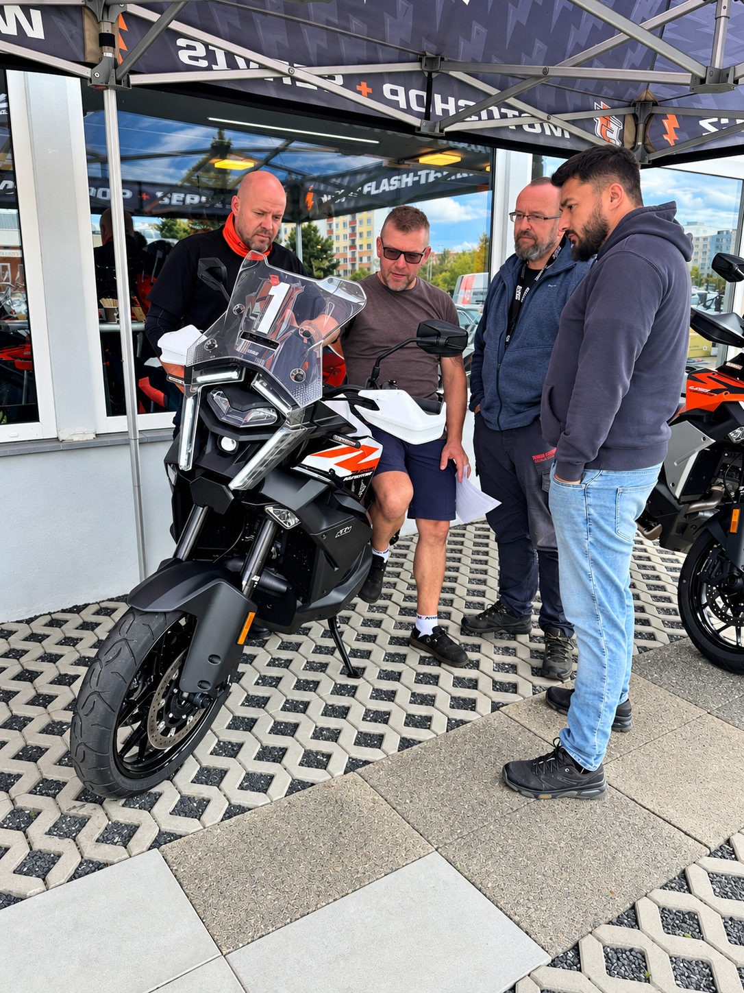 Návštěvníci si prohlížejí motocykl pod stanem Flash Teamu