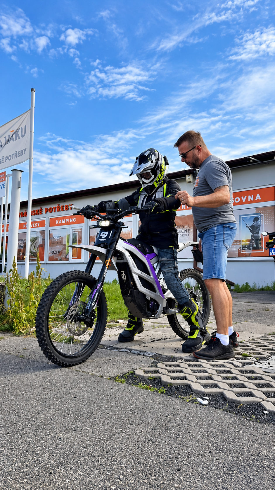 Jezdec zkouší elektrický motocykl před prodejnou