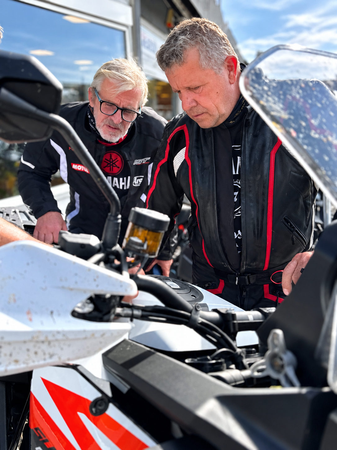 Dva jezdci si prohlížejí detaily motocyklu